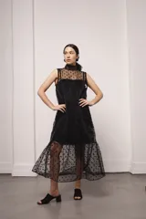 Vestido largo color ocre con estampado de cuadrados dorados, cuello alto y corte amplio. Incluye viso liso al tono.