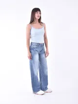 Musculosa blanca con tirantes finos en verde y estampado de palmeras en el pecho.