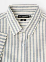 Camisa de manga corta efecto lino de Cuatroases, con estampado de rayas verticales en color azul y fondo beige. Presenta cuello camisero clásico y cierre frontal con botones blancos.