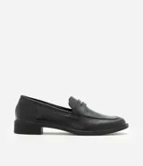Mocasín Satinato de mujer confeccionado en cuero negro con acabado liso, puntera redondeada, costuras visibles, tira decorativa en la pala y suela con taco bajo.