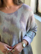 Sweater de punto con diseño animal print difuminado en tonos verdes y grisáceos, de corte holgado, cuello redondo y mangas largas con puños vueltos en color liso.