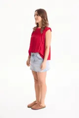 Blusa de viscosa negra sin mangas, con diseño fluido, cuello redondo y detalles de tablas verticales en el pecho con terminaciones de encaje en las sisas.