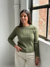 Sweater de punto con diseño de trenzas verticales, cuello redondo y mangas largas, en color verde oliva.