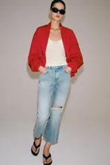 Jeans de tiro medio y corte bootcut cropped de Zara Woman Collection. Confeccionados en denim de efecto lavado en color celeste, presentan diseño de cinco bolsillos, trabillas para cinto, detalle de rotura en la rodilla izquierda y bajo evasé sin costuras. Cierre frontal con cremallera y botón metálico.