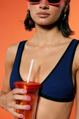 Conjunto de bikini azul con textura y detalles en negro. El corpiño es triangular con breteles fijos y bajo busto elastizado. La bombacha es vedetina con breteles regulables.