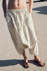 Pantalón de tiro medio confeccionado en nylon, con cintura elástica ajustable mediante cordones. Presenta bolsillos de plastrón en el delantero y bajo con acabado elástico.