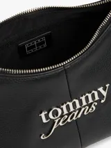 Cartera de hombro de poliuretano con acabado granulado y cierre de cremallera. Presenta una correa ajustable, un compartimento principal, un bolsillo interior con cremallera y el logo metálico de Tommy Jeans en la parte delantera.