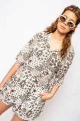 Camisa estampada con cuello clásico, mangas cortas y cierre frontal con botones.