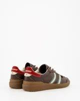 Championes Coolway modelo Kiro Espresso Pace de estilo retro, fabricados principalmente en gamuza color marrón. Presentan doble franja lateral en color blanco con bordes verdes, cordones claros, detalle rojo en la parte trasera del talón y suela de goma translúcida.