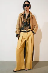 Jeans de tiro bajo y corte wide leg, color amarillo mostaza, con pliegues frontales, bolsillos ocultos y cierre frontal con cremallera, botón y ganchos metálicos.