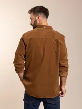 Camisa marrón de pana con cuello abotonado, manga larga con puños abotonados, corte regular fit y bolsillo en el pecho.
