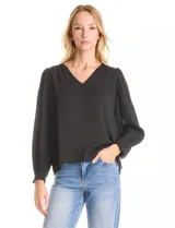Blusa negra de gasa, marca Tahari, con escote en V y detalle de punto smock en los hombros. Manga larga con terminación plisada y puños elásticos.