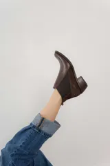Bota corta de cuero color marrón con elásticos laterales, taco bajo y punta redondeada.