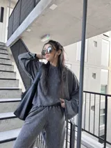 Buzo deportivo gris nevado con costuras externas y tela elastizada.