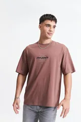 Remera negra de manga corta con corte oversize y cuello redondo. Presenta un estampado pequeño en la espalda con texto en naranja y blanco que dice "Free Spirits Freedom & Waves All Day / Every Day".