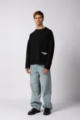 Sweater de punto liviano color negro con textura marcada, diseño de cuello redondo y calce holgado.