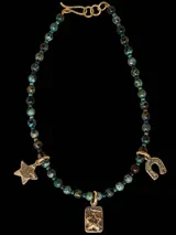 Collar de cuentas de piedra crisocola en tonos turquesa y verde, con dijes colgantes de bronce que incluyen una estrella, una medalla rectangular con estrella en relieve y una herradura.