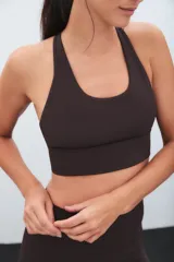 Top deportivo negro de escote redondo y espalda estilo nadadora, con banda elástica inferior para mayor soporte.