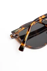 Lentes de sol polarizados con armazón redondo de carey marrón y micas oscuras.