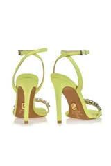 Sandalias de fiesta color amarillo flúor con taco aguja alto, tira delantera con apliques de strass y pulsera al tobillo con hebilla.