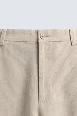 Pantalón de corte relaxed fit confeccionado en una mezcla de lyocell y lino. Presenta bolsillos frontales, bolsillos traseros de vivo y cierre frontal con cremallera y botón.