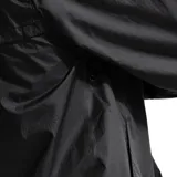 Campera rompevientos Nike Windrunner color negro, con capucha ajustable, cierre frontal completo y logo de la marca bordado en el pecho. Presenta diseño clásico con paneles en forma de V y puños elásticos.