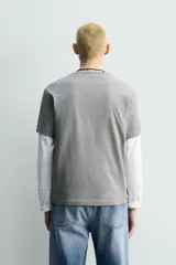 Camiseta de algodón gris jaspeado, de corte regular, con cuello redondo y manga corta.