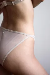 Bombacha nude de corte triangular y tiro bajo, confeccionada en tela translúcida con forro de algodón.