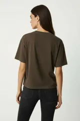 Remera de algodón, color gris oscuro con efecto gastado (acid wash), corte holgado y manga corta. Presenta un estampado frontal con motivos florales y texto en tonos rosados y blancos, incluyendo las frases "WILD ROSE ART", "ROSE POWER", "ST 1978" y "ROCKSTAR".