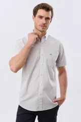 Camisa de manga corta con microcuadros en tonos celestes y blancos, calce slim, cuello con botones y bolsillo frontal con logo bordado.