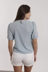 Blusa celeste con estampado de líneas verticales y mangas abullonadas cortas.