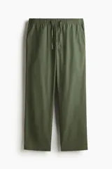 Pantalón verde militar de popelina de algodón, con cintura elástica y cordón ajustable. Presenta cierre decorativo y bolsillos laterales, con un corte relajado.