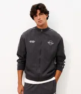 Campera deportiva de helanca color gris oscuro, con diseño de raya diplomática fina, cuello bomber, cierre frontal y bordados en el pecho.