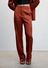 Pantalon de tiro alto con diseño recto, confeccionado en tejido satinado fluido con estampado de topos. Cuenta con trabillas en la cintura, dos bolsillos laterales y cierre oculto de botón, gancho y cremallera.