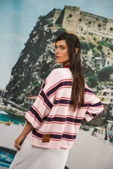 Remera rosa con rayas horizontales azul marino y bordó, cuello tipo polo marrón con botones y mangas cortas amplias.