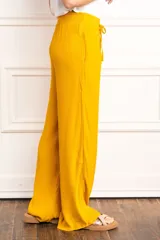 Pantalón palazzo amarillo mostaza de viscosa con cintura elástica y cordón ajustable.