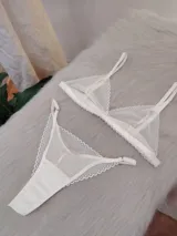 Conjunto de lencería compuesto por un corpiño triangular y una bombacha tipo colaless, confeccionados en encaje con diseño de ondas y detalles en satén.