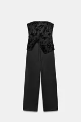 Mono largo de escote strapless con cuerpo superior en tejido texturizado con diseño floral y pantalón de corte recto en tejido liso. Presenta un cinturón fino tipo lazada en la cintura y cierre lateral oculto.