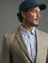 Saco sport de gamuza ecológica, con cierre de dos botones frontales, solapas clásicas y bolsillos laterales con solapa.