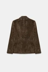 Blazer de ante color marrón, con cuello solapa, hombreras, manga larga y cierre frontal cruzado con botones. Cuenta con bolsillos delanteros de doble vivo.