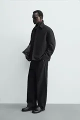 Sobrecamisa de corte regular confeccionada en tejido con mezcla de lana, color marrón oscuro. Presenta cuello solapa, cierre frontal con botones, mangas largas con puños abotonados y bolsillos laterales.