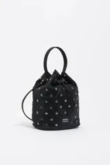 Bolso tipo bucket de nylon negro con tachas metálicas plateadas distribuidas por toda la superficie. Cuenta con cierre de cordón ajustable, asa de mano superior y correa larga para llevar al hombro o cruzado. Incluye el logo de la marca estampado en la parte frontal.