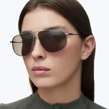 Lentes de sol estilo aviador oversize con montura metálica fina en color gris y doble puente. Lentes polarizadas en tono marrón con acabado pulido.