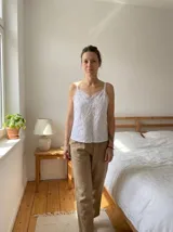 Top blanco de algodón con broderie, breteles finos y escote en V con puntilla.