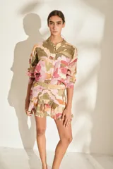 Minifalda color crudo con estampado de paisaje costero, cintura elástica fruncida y volados en el ruedo.