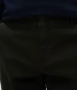 Pantalón slim de sarga lavada para hombre, de corte ajustado y color beige, con bolsillos laterales y traseros, trabillas para cinturón y cierre frontal con botón y cremallera.