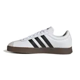 Championes Adidas modelo VL Court, de color blanco con las tres tiras clásicas en negro y suela de goma marrón. Presenta puntera reforzada en gamuza gris claro y cordones blancos.