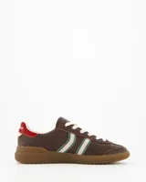 Championes Coolway modelo Kiro Espresso Pace de estilo retro, fabricados principalmente en gamuza color marrón. Presentan doble franja lateral en color blanco con bordes verdes, cordones claros, detalle rojo en la parte trasera del talón y suela de goma translúcida.