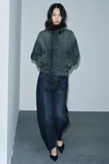 Jeans de tiro alto con corte barrel y diseño tapered, confeccionados en denim con efecto lavado y detalle de raya planchada. Presentan cintura con trabillas, cierre frontal con cremallera y botón, y bolsillos funcionales en delantero y espalda.