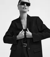 Blazer oversized de crepé color beige, de corte sastre, con solapas de muesca y cierre frontal con un botón.